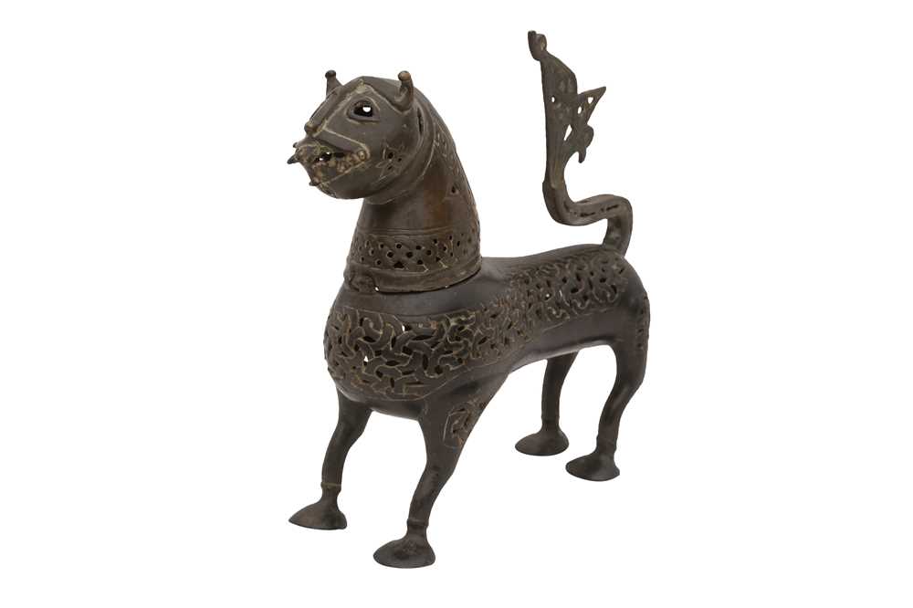 A CAST OPENWORK BRONZE INCENSE BURNER IN THE SHAPE OF A LION Eastern Iran or Afghanistan, the body 11th - 12th century, the head, neck, and tail later additions