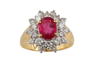 Lot 102 - A ruby and diamond cluster ring The oval-cut...