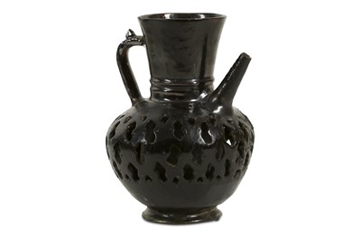 Lot 880 - A BLACK-GLAZED PIERCED POTTERY EWER Iran, 12th...