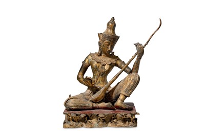 Lot 129 - A Thai gilt metal figure of a female musician,...