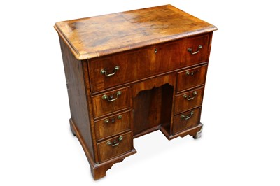 Lot 743 - A Georgian walnut kneehole desk, the quarter...