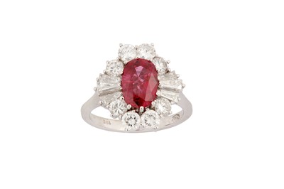 Lot 161 - A ruby and diamond cluster ring The oval-cut...