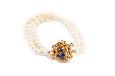 Lot 304 - A two-strand cultured pearl bracelet, with an...