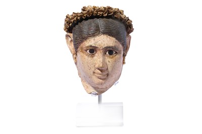 Lot 190 - AN EGYPTIAN STUCCO PAINTED HEAD OF A WOMAN...