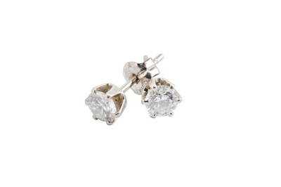 Lot 52 - A pair of diamond earstuds, each claw-set with...
