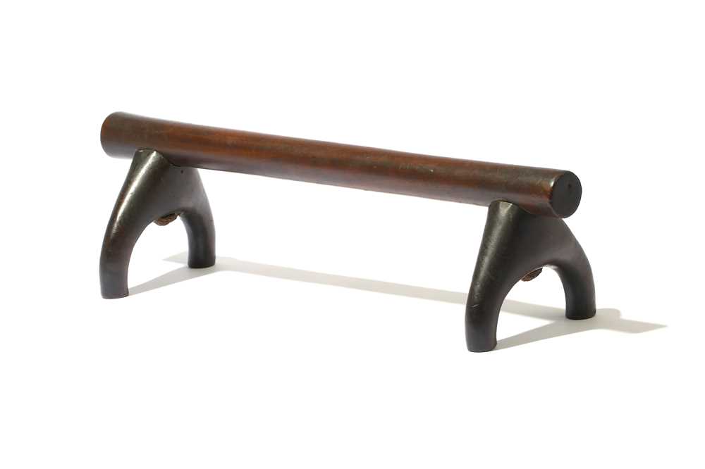 Lot 239 - A WOOD HEADREST With a dark, polished patina,...
