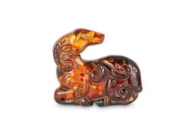 Lot 115 - A CHINESE GILT-SPLASH AMBER CARVING OF A RAM. ...
