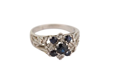 Lot 388 - A sapphire and diamond ring, the circular-cut sapphire and single-cut diamond cluster between openwork shoulders