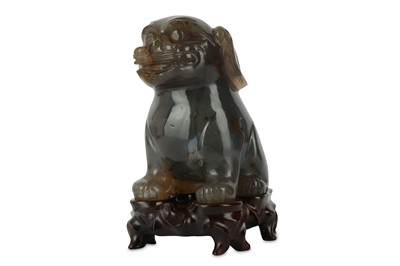 Lot 551 - A CHINESE AGATE CARVING OF A LION DOG. Seated...