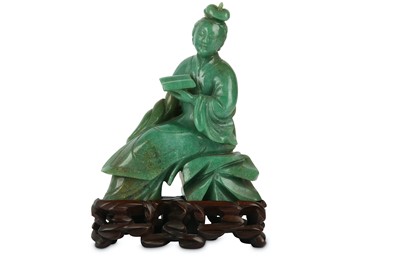 Lot 104 - A CHINESE GREEN HARDSTONE CARVING OF A LADY...