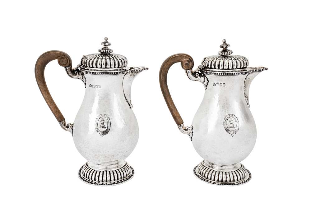 Lot 525 - A pair of Edwardian ‘art and crafts’ sterling silver hot water pots, London 1906 by Elkington & Co