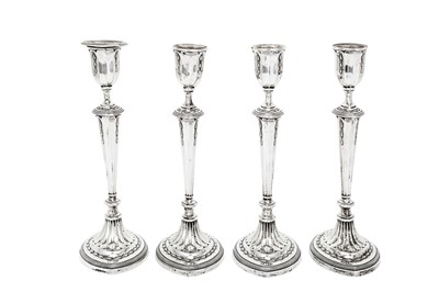 Lot 386 - A set of four George V sterling silver candlesticks, Sheffield 1910 by James Deakin & Sons