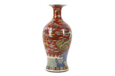 Lot 234 - A red ground famille rose 'mythical beasts' vase.