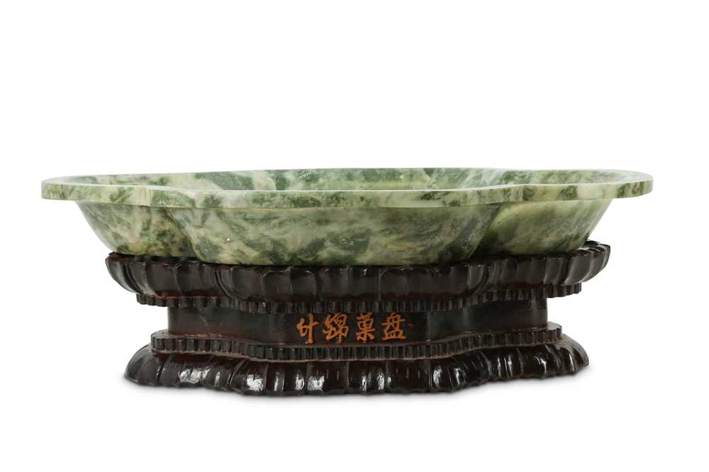 Lot 222 - A Chinese nephrite quatrefoil plate with wood stand.