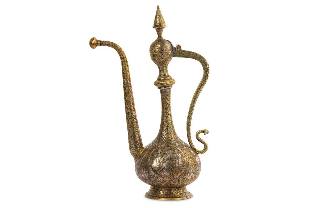 Lot 320 - A QAJAR SILVER-INLAID BRASS EWER