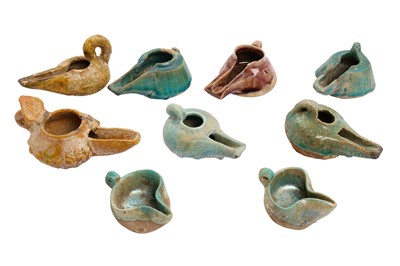 Lot 285 - A COLLECTION OF NINE IRANIAN MONOCHROME-GLAZED POTTERY OIL LAMPS