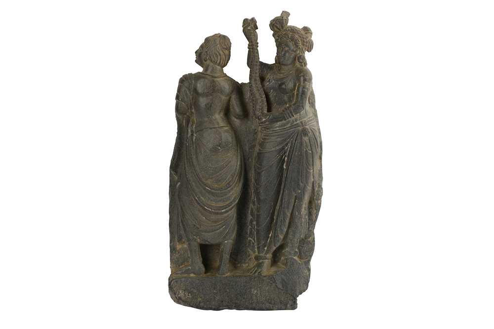 Lot 174 - A GREY SCHIST CARVING WITH A STANDING PAIR