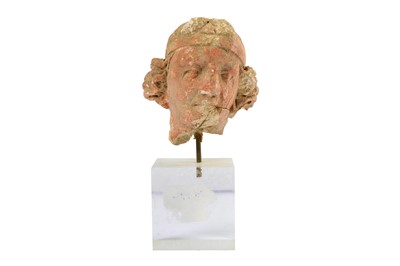 Lot 183 - A SMALL RED-PAINTED STUCCO BODHISATTVA HEAD
