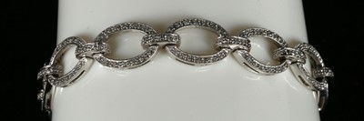 Lot 319 - A 14K white gold and dial set oval link bracelet.