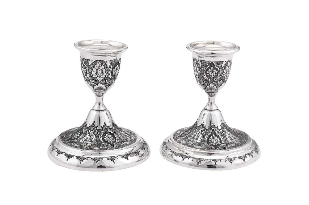 Lot 87 - WITHDRAWN A pair of mid-20th century Iranian (Persian) unmarked silver dwarf candlesticks, Isfahan circa 1960