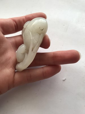 Lot 122 - A CHINESE WHITE JADE 'MONKEY AND PEACHES' CARVING.