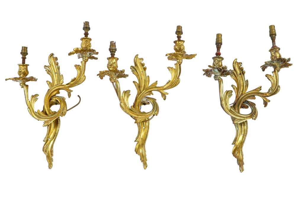 Lot 419 - A set of three early 20th Century Louis XV style cast gilt metal twin branch wall sconces
