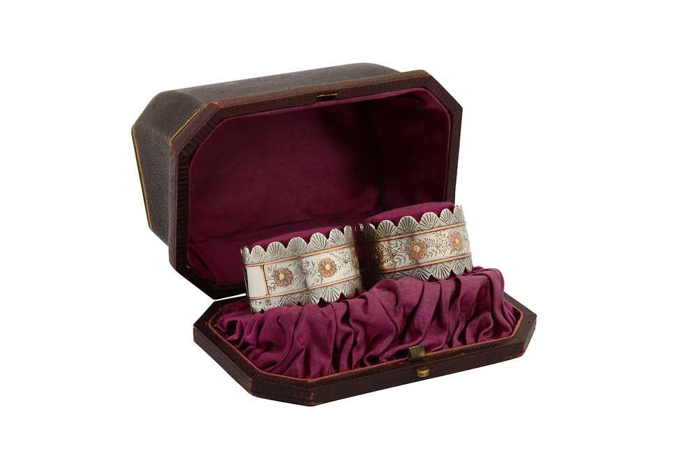 Lot 13 - A cased pair of Victorian sterling silver and unmarked gold napkin rings, Birmingham 1885 by Colen Hewer Cheshire