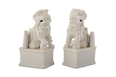 Lot 36 - A PAIR OF CHINESE BLANC-DE-CHINE LION DOG JOSS STICK HOLDERS.