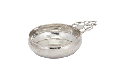 Lot 469 - A Queen Anne unmarked silver single handle porringer, probably London circa 1710