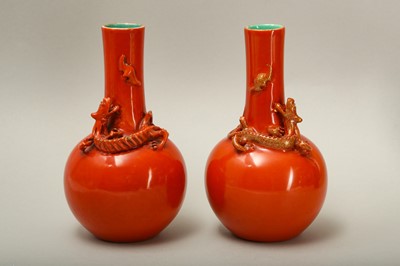 Lot 66 - A PAIR OF SALMON RED-GLAZED 'DRAGON' VASES.