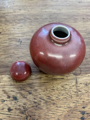 Lot 130 - A SMALL CHINESE COPPER RED-GLAZED JAR AND COVER.