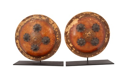 Lot 404 - A PAIR OF GILT AND LACQUERED LEATHER CEREMONIAL SHIELDS