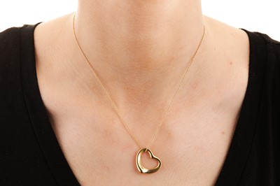 Lot 217 - A gold 'Open Heart' pendant necklace and earstuds, by Elsa Peretti for Tiffany & Co.