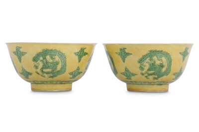 Lot 565 - A PAIR OF CHINESE YELLOW AND GREEN-GLAZED 'DRAGON' BOWLS.
