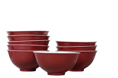 Lot 126 - A SET OF NINE SMALL CHINESE COPPER RED-GLAZED BOWLS.
