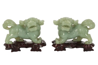 Lot 306 - A PAIR OF MODERN CHINESE CARVED PALE GREEN JADEITE LION DOGS