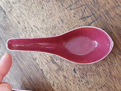 Lot 128 - A SET OF FIVE CHINESE COPPER RED GLAZED SPOONS.