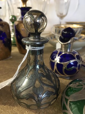 Lot 123 - A collection of six early 20th century glass and silvered metal perfume bottles with stoppers