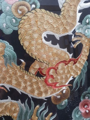 Lot 104 - A CHINESE RECTANGULAR BLACK-GROUND EMBROIDERED SILK 'DRAGON' PANEL.