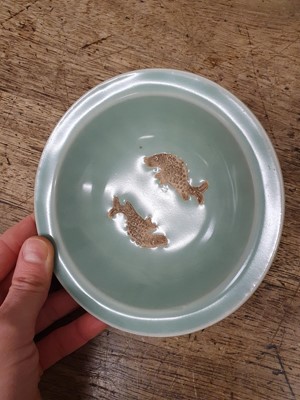 Lot 512 - A CHINESE CELADON 'DOUBLE FISH' SAUCER.