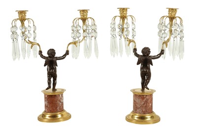 Lot 106 - A PAIR OF EARLY 20TH CENTURY BRONZE AND CUT GLASS FIGURAL CANDELABRA DEPICTING CUPID