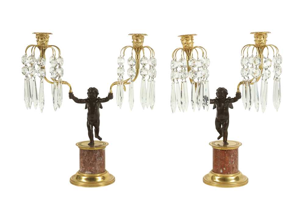 Lot 106 - A PAIR OF EARLY 20TH CENTURY BRONZE AND CUT GLASS FIGURAL CANDELABRA DEPICTING CUPID