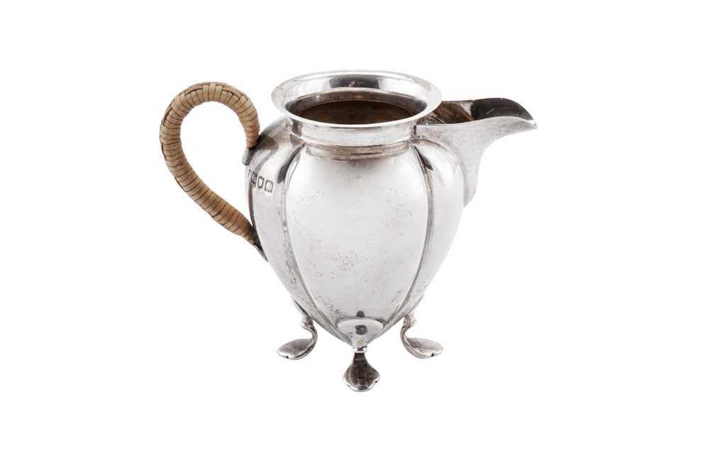 Lot 265 - An Edwardian 'Arts and Crafts' sterling silver cream jug, London 1904 by Hukin and Heath