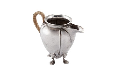 Lot 265 - An Edwardian 'Arts and Crafts' sterling silver cream jug, London 1904 by Hukin and Heath