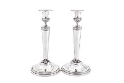 Lot 130 - A pair of early 19th century French First Empire 950 standard silver candlesticks, Paris 1805-09 by Richard-Emile Agu (reg. 1805-6)