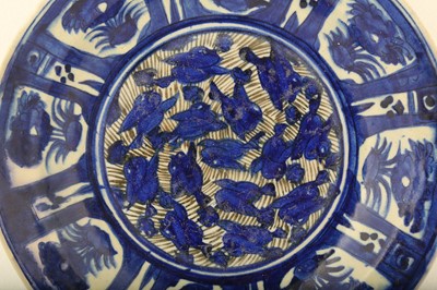 Lot 80 - A LARGE LATE QAJAR BLUE AND WHITE POTTERY CHARGER