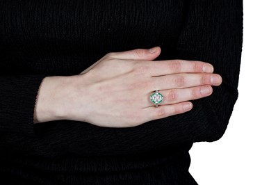Lot 64 - An emerald and diamond dress ring