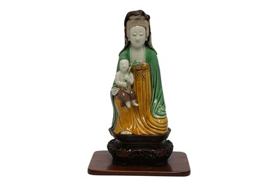 Lot 610 - A CHINESE SANCAI-GLAZED BISCUIT 'GUANYIN AND CHILD' GROUP.