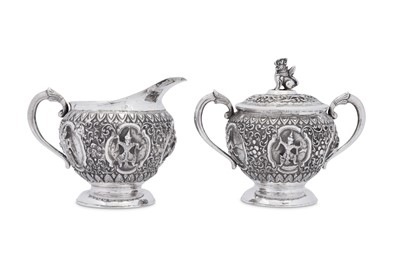 Lot 185 - An early 20th century Burmese unmarked silver milk jug and covered twin handled sugar bowl, Thayetmyo circa 1900