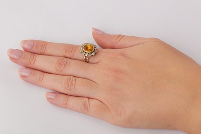 Lot 99 - A yellow sapphire and diamond cluster ring